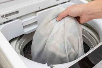 衣類を洗濯ネットに入れて洗濯機で洗う © 木村　亨