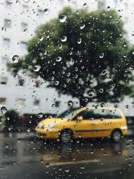 A yellow car photographed through the glass window while driving