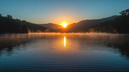 Obraz premium Majestic sunrise illuminating a serene lake, framed by distant mountains and soft morning mist.