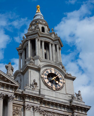 A captivating stock photo of the majestic clock tower of St. Paul's Cathedral in London, UK. The image captures the architectural beauty of the historic landmark, set against a backdrop of a blue sky.