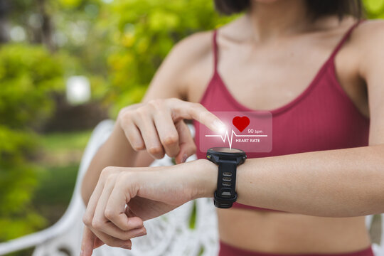 Close up person Point to smartwatch displaying heart rate application. Monitoring virtual display measure heart rate before after physical exercise. wristwatch checking heart beats and pulse. - Powered by Adobe