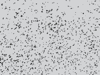 Scattered ash particle vector illustration. Monochrome grunge texture with random black specks on gray background. Mottled pattern with random spots