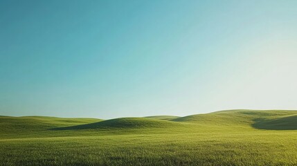 Fototapeta premium Serene Meadow: A vast expanse of rolling green hills stretches toward a vibrant blue sky, bathed in the warm glow of the setting sun. This tranquil landscape evokes a sense of peace and vastness.
