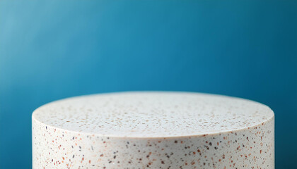 White round terrazzo podium for product presentation. Empty pedestal. Blue wall. Mock-up.