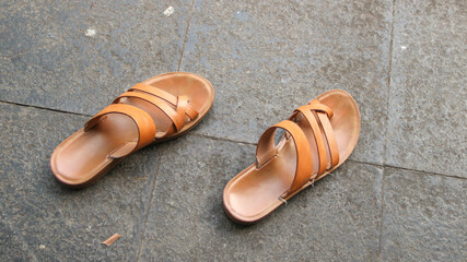 Brown sandals isolated on a cement floor background.