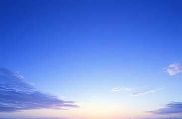 Obraz premium Wispy clouds enhance the beauty of the sunrise against a blue expanse.