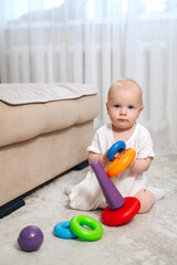 healthy curious child plays with educational colorful toy pyramid