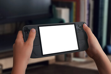 Close-up of a handheld gaming console mockup, hands holding it, blurred living room background with books, ideal for showcasing game design and interactive entertainment