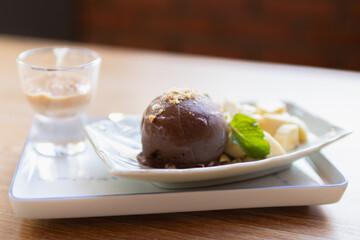 Delicious dessert featuring chocolate ice cream, banana slices, and a shot glass of creamy beverage. Perfect for sweet indulgence.