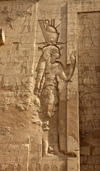 Wall relief of the goddess Hathor wearing the Double Crown of Egypt on the entrance pylon to the Temple of Horus, Edfu Egypt
