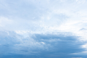 Beautiful fluffy white clouds drift across a bright blue summer sky