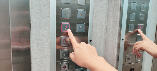 finger presses the number on the elevator button