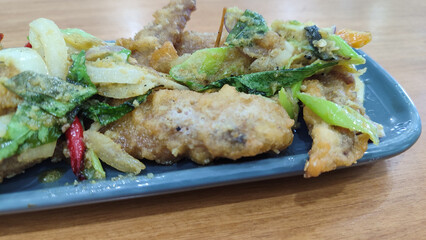 Fried chicken with salted egg in blue ceramic plate isolated with white. Selective focus.