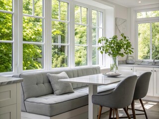 Naklejka premium Modern White Kitchen with Grey Sofa and Dining Table Overlooking Lush Green Foliage - Stylish Home Interior Design Inspiration