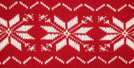 White color eight pointed star knitted pattern on sweater. White stars on red background, studio shot, indoors.