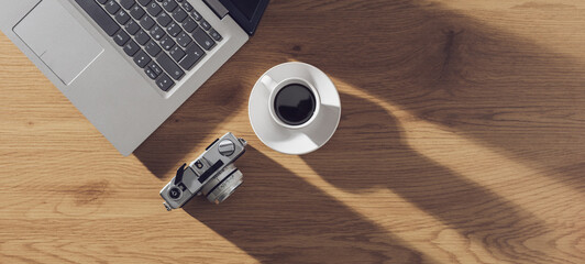 Top view desk with laptop, camera and coffee