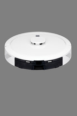 white robot vacuum cleaner on a gray background with copyspace