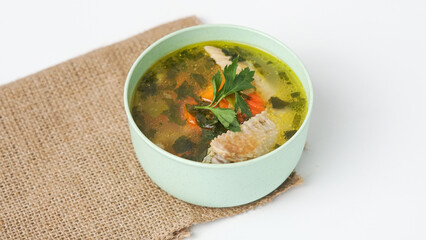 Homemade chicken soup in a bowl on a white background