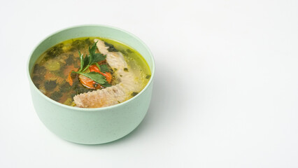Homemade chicken soup in a bowl on a white background