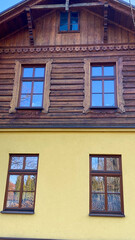 A yellow house with three windows on the side of it