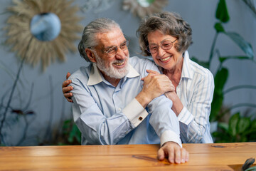 elderly people sitting at the table woman hugging her husband happy old age elderly couple pleasant memories leisure time in old age warm feelings support in old age difficult times