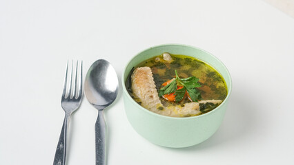 Homemade chicken soup in a bowl on a white background