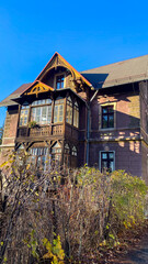 A large brown house with a brown roof and windows