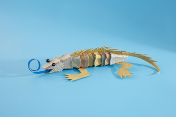 recycled empty egg carton box iguana or lizard craft on a plain background, step in creative...