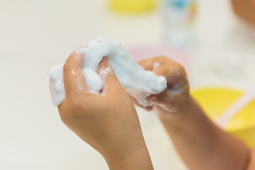 Pulling slimes in the hands of a child. Skwooshi stretchable dough for children.