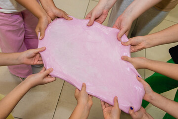 Pulling slimes in the hands of a child. Skwooshi stretchable dough for children.