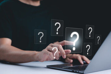 Question Mark and Problem Solving Concept. A person using a laptop with floating question marks, symbolizing brainstorming, problem-solving, and finding answers to business FAQs. creativity and ideas,