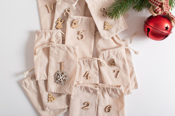 Christmas advent calendar with gift velvet bags and wooden numbers on a white background. Eco-friendly