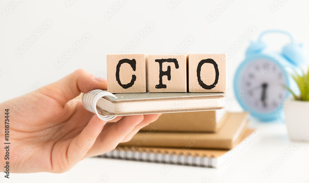 Aufkleber text cfo on a wooden cube blocks on notepad background