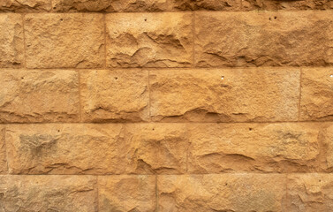 Close up of large block sandstone wall with small holes