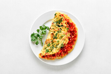 Stuffed omelette with red bell pepper and green onion on plate
