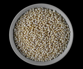 Puffed millet in bowl isolated on black, top view