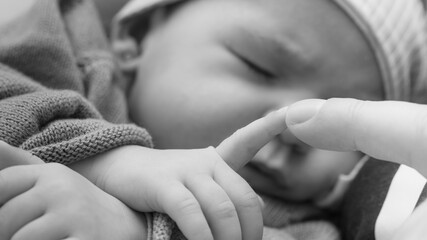 newborn finger touching hand mother