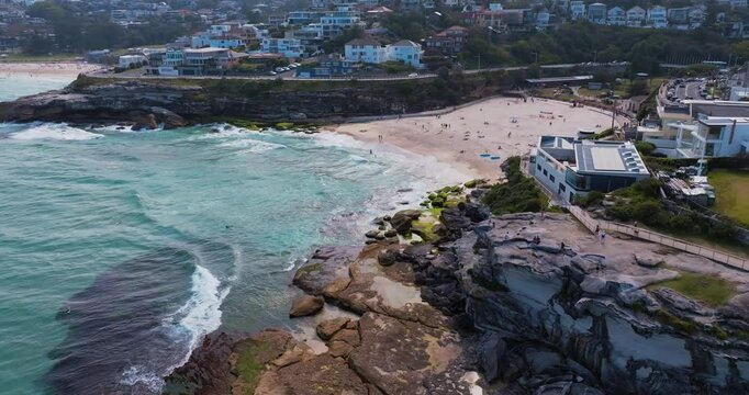 Aerial drone view of iconic Tamarama Beach coastline with turquoise water in Sydney, Australia during summer on a sunny day.