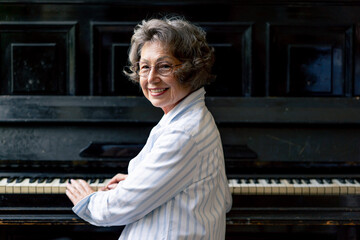 an elderly woman sits at the piano playing a melody learning new chords old age memories of an...