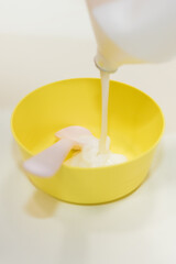 The child prepares a slime in a cup. Skwooshi stretchable dough for children.