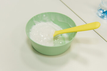 The child prepares a slime in a cup. Skwooshi stretchable dough for children.