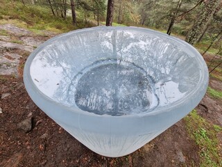 A large clear plastic bowl placed on the ground, showcasing its transparent design and spacious interior