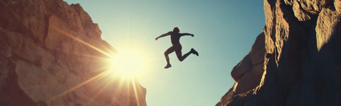 Hiker leaping across gap between cliffs at sunset - Powered by Adobe