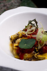 Italian pasta, ravioli, with tomato and vegetables.
