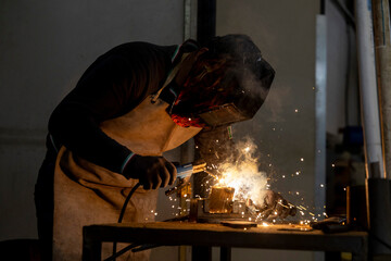 professional welder Worker using tig welding method on a piece of steel