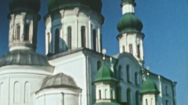Ancient Christian church with white walls and green domes. Yelets Monastery cultural, historical, spiritual heritage of Kievan Rus landmark. Baroque religious building. Vintage film. Retro archive