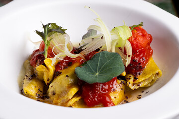 Italian pasta, ravioli, with tomato and vegetables.