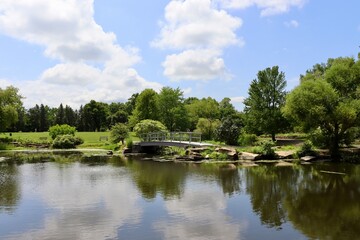 The footbridge at the pond in the park on a sunny day.