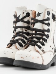 A pair of white boots with black laces and a star on the front