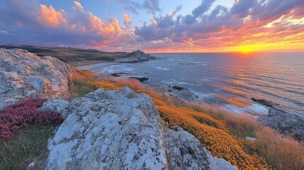 A vibrant sunset over a coastal landscape with colorful flowers and rocky terrain.